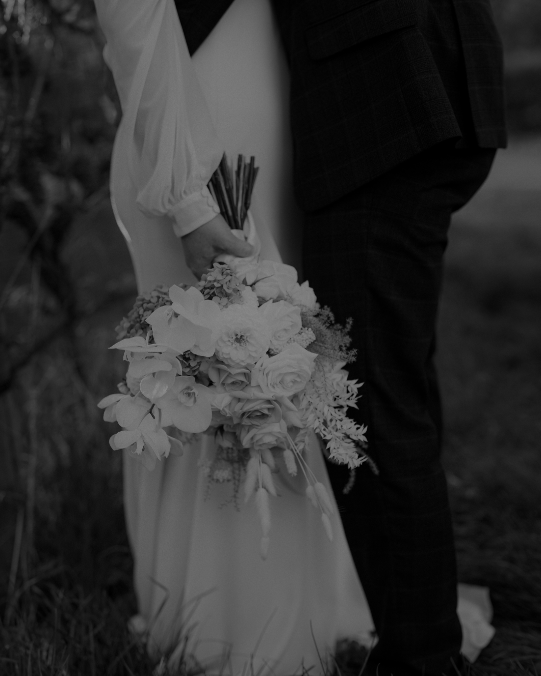 Dettaglio del bouquet della sposa accanto allo sposo